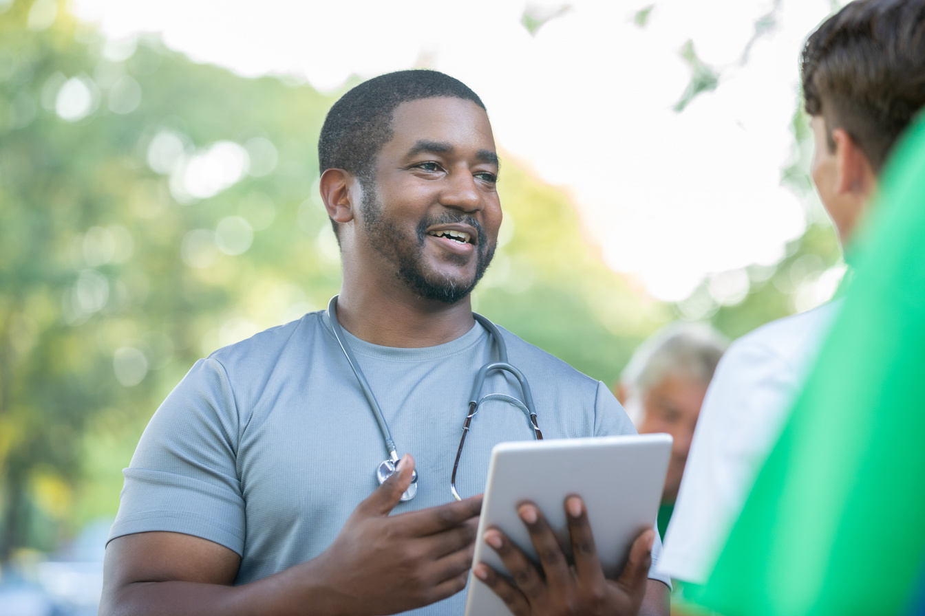 Doctor talks with community member during outdoor health fair